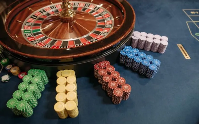 Poker chips beside casino roulette