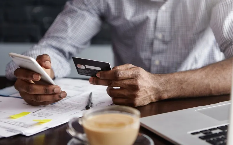 close-up-shot-african-man-s-hands-holding-mobile-credit-card