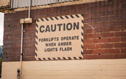 Caution sign on a brick wall indicating forklift operation safety in Melbourne