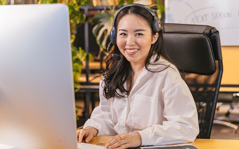 Businesswoman with headset working at her desk in an office environment